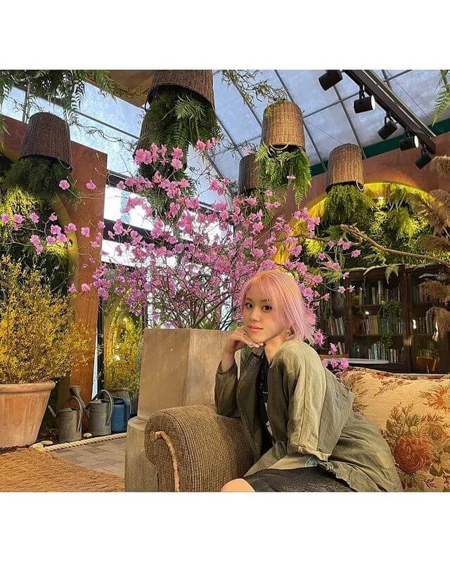 Chaeyoung en un sofa con algunas plantas de fondo