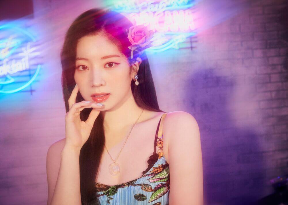 Dahyun en un ambiente brilante y una flor en su pelo durante la promoción de taste of love fallen ver