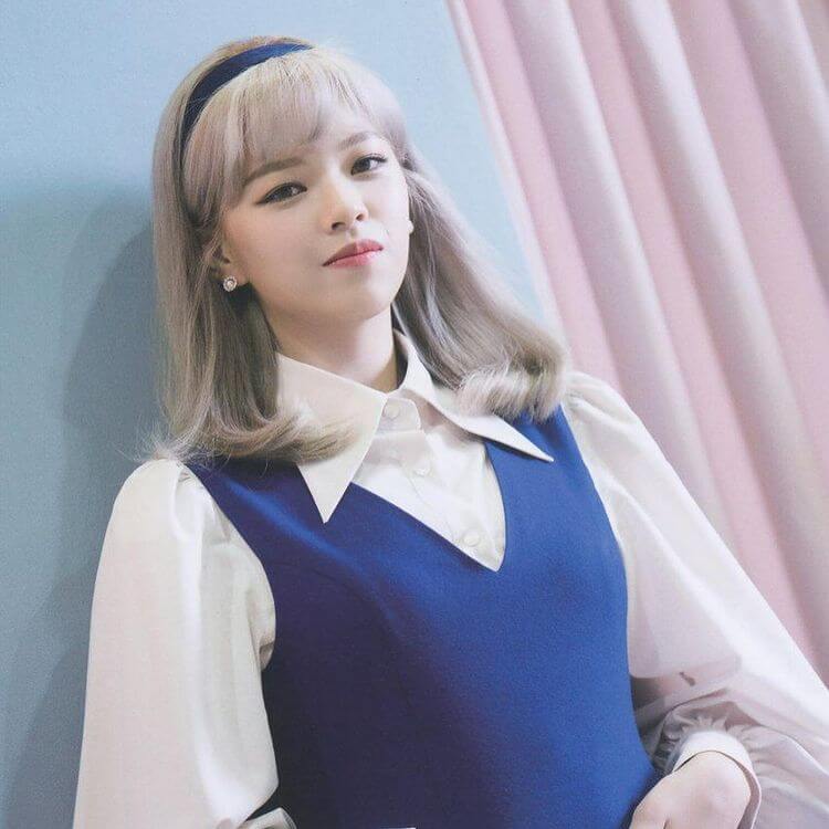 Jeongyeon con saco azul y soriendo