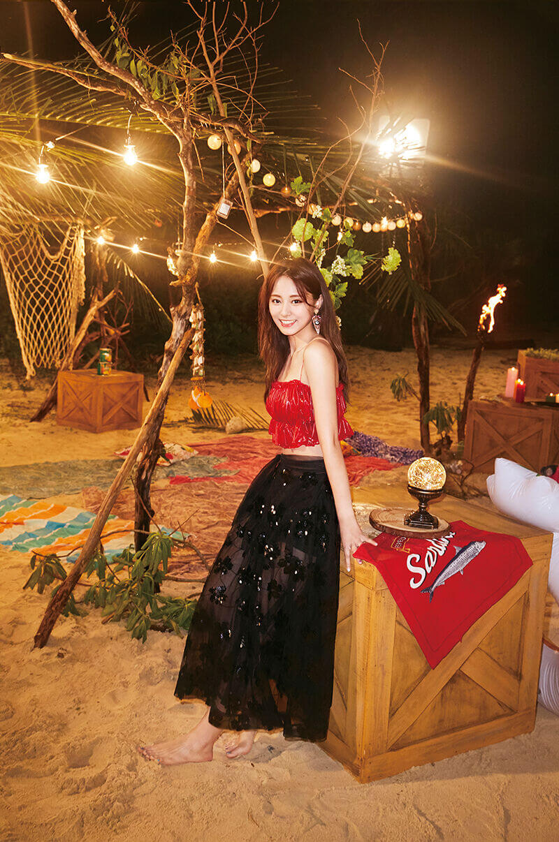 Tzuyu de noche, en la playa con un top rojo y vestido negro