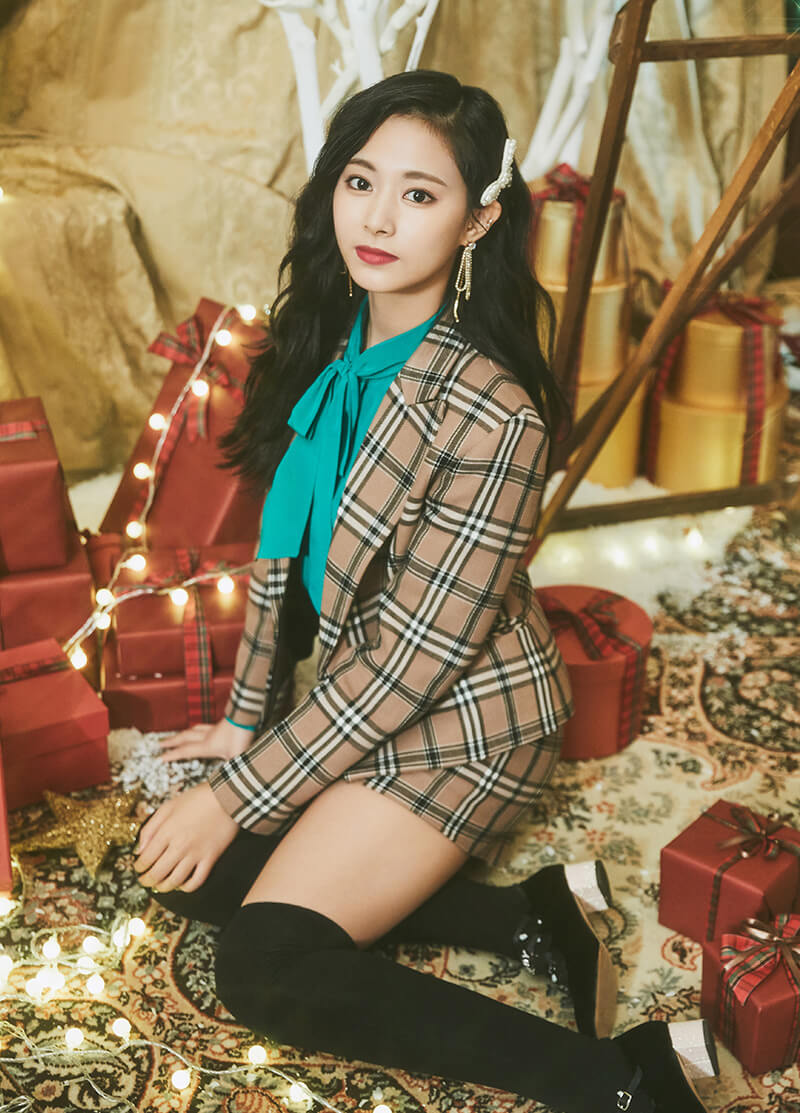 Tzuyu con un sueter de rayas y regalos navideños a su alrededor